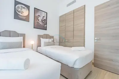 two beds in a room with white walls at Stylish 2BR Stay Near Marina Beach and Ain Dubai, Steps from Shops and Restaurants, Studio One, Dubai Marina by Deluxe Holiday Homes in Dubai