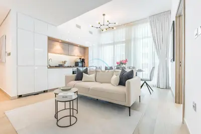 a living room with a white couch and a table at Stylish 2BR Stay Near Marina Beach and Ain Dubai, Steps from Shops and Restaurants, Studio One, Dubai Marina by Deluxe Holiday Homes in Dubai