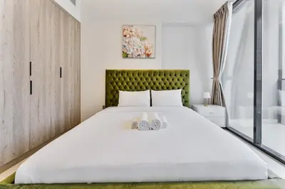 a bedroom with a large bed with two shoes on it at 2 Bed With Balcony Near World Renowned Golf Clubs in Dubai