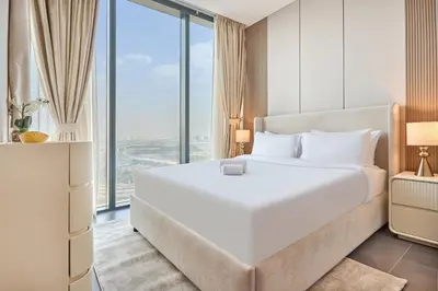 a bedroom with a large white bed and large windows at STAY BY LATINEM Luxury 1BR Plus Holiday Home CB 2408 Near Burj Khalifa in Dubai
