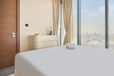 a bedroom with a white bed and a large window at STAY BY LATINEM Luxury 1BR Plus Holiday Home CB 2408 Near Burj Khalifa in Dubai