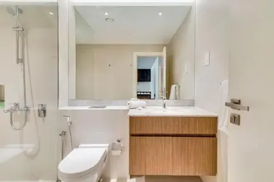 a bathroom with a toilet and a sink and a shower at GuestReady - Chic coastal living at Port de La Mer in Dubai