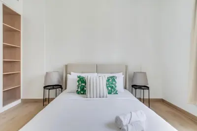 a bedroom with a white bed with green pillows at GuestReady - Chic coastal living at Port de La Mer in Dubai