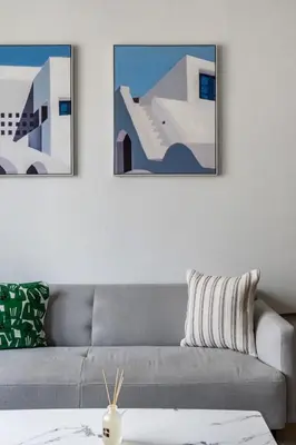 a living room with a gray couch and two pictures at GuestReady - Chic coastal living at Port de La Mer in Dubai