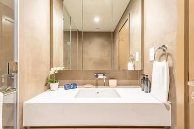 a bathroom with a white sink and a mirror at Liv Marina Panoramic 3BR with Palm & Sea View in Dubai