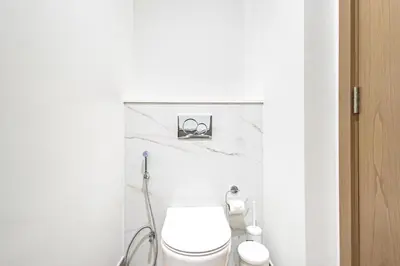 a white bathroom with a toilet and a sink at Liv Marina Panoramic 3BR with Palm & Sea View in Dubai