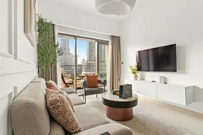 a living room with a couch and a tv at FIRST CLASS 2BR Burj Khalifa & Pool Views in Dubai