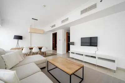 a living room with a couch and a tv at Exquisite 2BR Apartment in Dubai Marina in Dubai