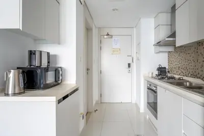 a white kitchen with a sink and a microwave at GuestReady - Canal View Studio | Near Dubai Mall in Dubai