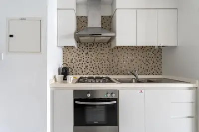a kitchen with white cabinets and a stove top oven at GuestReady - Canal View Studio | Near Dubai Mall in Dubai
