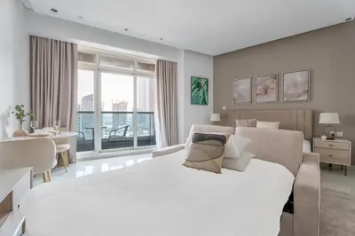 a bedroom with a large white bed and a desk at GuestReady - Canal View Studio | Near Dubai Mall in Dubai