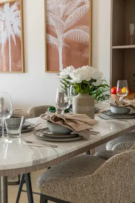 a dining room table with plates and flowers on it at Frank Porter - Rahaal 2 in Dubai