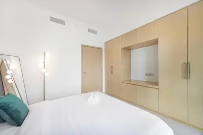 a bedroom with a large white bed with a television at New LUX 1 BDR apartment in Downtown Dubai in Dubai