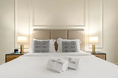 a bedroom with a large white bed with two lamps at FIRST CLASS 2BR Vibrant Retreat Near JBR Beach in Dubai