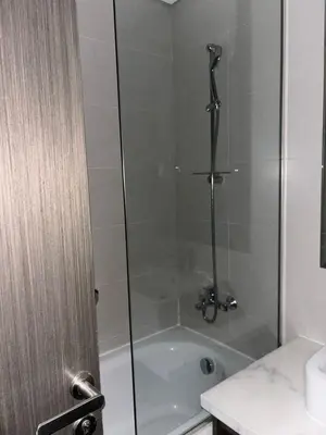 a bathroom with a shower with a tub at Luxury Canal View Studio with Pool Damac Maison Prive in Dubai