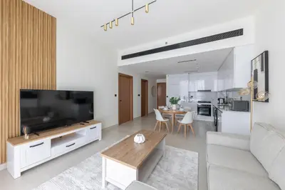 a living room with a couch and a tv and a table at Modern 1BR Apartment with City View in Dubai