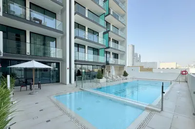 a large swimming pool in front of a building at Modern 1BR Apartment with City View in Dubai