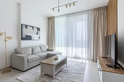 a white living room with a couch and a table at Modern 1BR Apartment with City View in Dubai