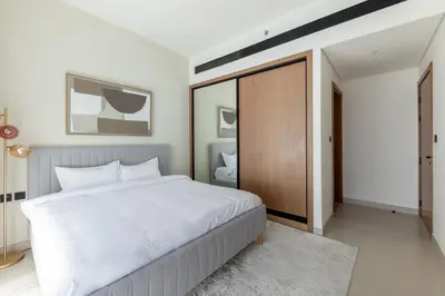 a bedroom with a large white bed and a mirror at Modern 1BR Apartment with City View in Dubai