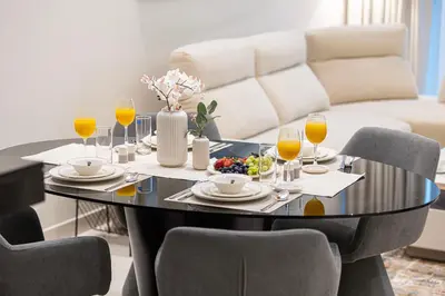 a black table with glasses of orange juice and food on it at Maison Distinction Suites by Hostiva - Burj and Fountain View in Dubai