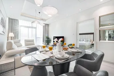 a living room with a table and chairs at Maison Distinction Suites by Hostiva - Burj and Fountain View in Dubai