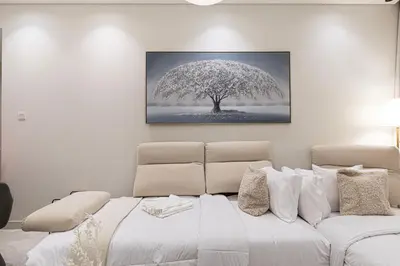 a bedroom with a white bed and a tree at Maison Distinction Suites by Hostiva - Burj and Fountain View in Dubai