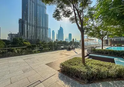 a park with a tree and a view of a city at Ultra-Luxury Burj & Fountain Suite at Address Opera in Dubai