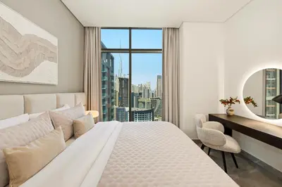a bedroom with a white bed and a large window at Spacious & Cozy 2BD Apartment Peninsula One, Dubai in Dubai