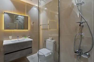 a bathroom with a shower and a toilet and a sink at Luxury Silicon Oasis Studio Near Mall & Airport in Dubai