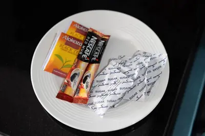 a white plate with pens and a book and some writing at Luxury Silicon Oasis Studio Near Mall & Airport in Dubai