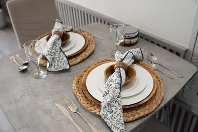 a table with plates and napkins on top at Luxury Silicon Oasis Studio Near Mall & Airport in Dubai