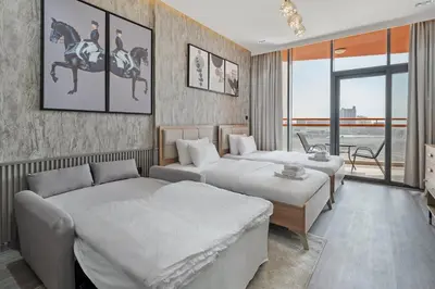 a bedroom with two beds and a couch at Luxury Silicon Oasis Studio Near Mall & Airport in Dubai