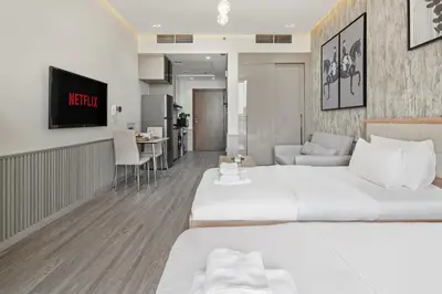 a hotel room with two beds and a kitchen at Luxury Silicon Oasis Studio Near Mall & Airport in Dubai
