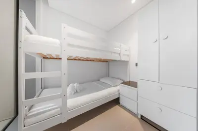 a white bedroom with a bunk bed and white cabinets at 3BR Luxury Stay with Maid Room and Views of Ain Dubai & Sea in Dubai