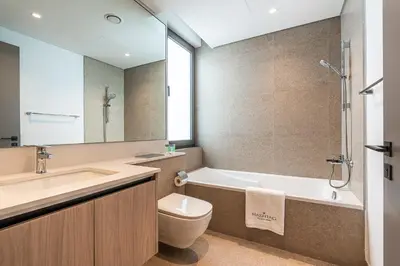 a bathroom with a tub and a toilet and a sink at Modern Townhouse in Tilal Al Ghaf I Aura Gardens in Dubai