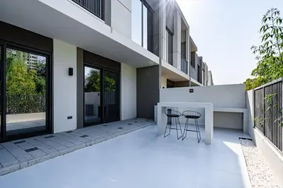 a patio with two chairs and a table on a building at Modern Townhouse in Tilal Al Ghaf I Aura Gardens in Dubai