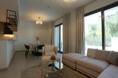 a living room with a couch and a table at Modern Townhouse in Tilal Al Ghaf I Aura Gardens in Dubai
