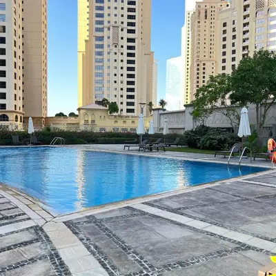 a large swimming pool in a city with buildings at 1 BR Apartment in Dubai Marina - Paloma Tower - Sea View - 3 Mins away from Tram & Beach in Dubai
