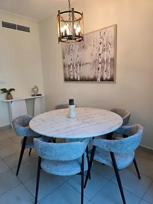 a dining room with a table and blue chairs at 1 BR Apartment in Dubai Marina - Paloma Tower - Sea View - 3 Mins away from Tram & Beach in Dubai