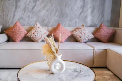 a vase on a table in a living room with a couch at Luxury Grande 48 with Burj Khalifa & Fountain Views in Dubai