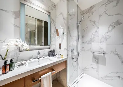 a bathroom with a shower and a sink and a mirror at Burj Khalifa & Fountain Sky Suite on The Address Opera in Dubai