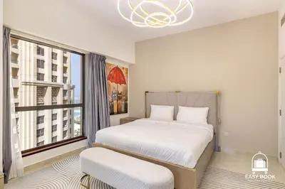 a bedroom with a bed and a large window at Spacious 4BR Stay Sea JBR Views Sadaf 8 EB in Dubai