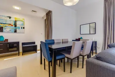 a dining room with a table and chairs and a couch at Modern 2 BDR Apartment with Sea View Shams 1 JBR in Dubai