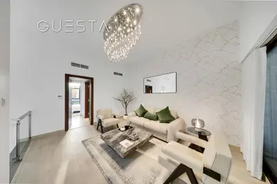 a living room with a couch and a chandelier at Senses at the Fields - Villa with a Private Pool in Dubai