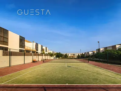 a tennis court in front of a building at Senses at the Fields - Villa with a Private Pool in Dubai