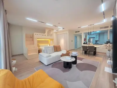 a living room with a white couch and a kitchen at Stylish JBR Studio Beach View EB in Dubai