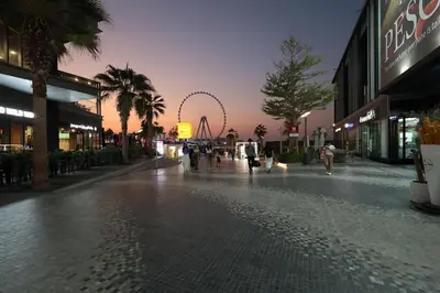 a city street with a roller coaster in the background at Stylish JBR Studio Beach View EB in Dubai