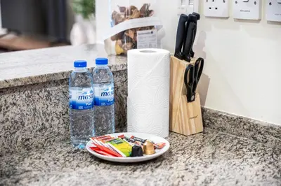 a counter with two bottles of water and a paper towel at Surrounded by Nature Near Internet & Media City in Dubai