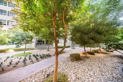 a garden with trees and plants in front of a building at Surrounded by Nature Near Internet & Media City in Dubai