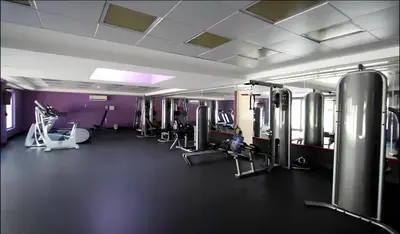 a gym with cardio equipment and purple walls at Surrounded by Nature Near Internet & Media City in Dubai